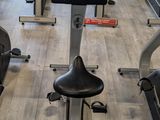 rows of stationary exercise bikes in a gym room with computers on them