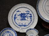 several blue and white plates and bowls are on a table