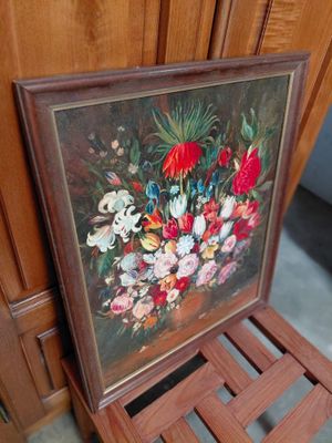 a picture of a painting of flowers on a wooden chair