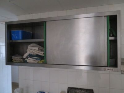 une armoire en acier inoxydable dans la salle de bains, avec des serviettes sur l'étagère