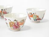 three small bowls with asian designs on them on a white surface