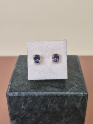 a pair of blue sapphire earrings sitting on top of a marble block