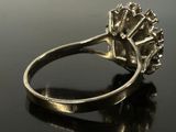 a silver ring with a diamond on it on a black surface