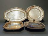 two silver plated trays sitting on top of a black table