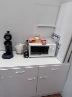 un micro-ondes posé sur un meuble blanc dans une cuisine