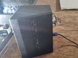 a black box sitting on top of a wooden table next to a laptop