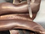 pair of brown leather ballet shoes with a strap and buckles