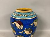 un vase bleu et jaune orné de poissons