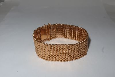 bracelet made of gold plated metal on a white surface