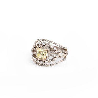 un gros plan d'une bague ornée d'un diamant jaune entouré de diamants blancs