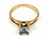 a close up of a gold ring with a blue topaz stone