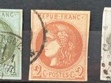 three different colored stamps on a black surface with a woman in a headdress