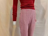 a mannequin of a woman wearing a red sweater and checkered pants