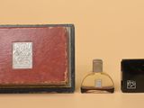 a small box with a small bottle of perfume and a small box with a small bottle of perfume