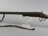 an old gun on a stand with a glass holder