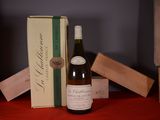 a bottle of wine sitting on a table next to a box of wine