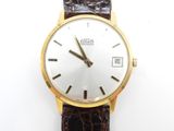 une image d'un gros plan d'une montre-bracelet sur une surface blanche