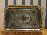 a silver tray on a wooden table with a blue and white striped wall behind it