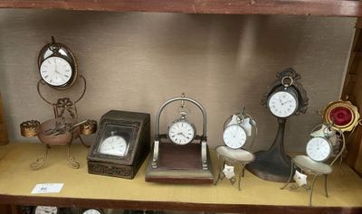 de nombreuses horloges différentes posées sur une étagère dans une pièce