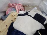 a pile of clothes sitting on top of a bed