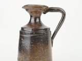 brown and black jug with handle on a white background