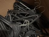 a cardboard box filled with black clothes hangers