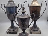 three silver vases sitting next to each other on a table