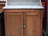 une armoire en bois surmontée d'un lavabo en marbre