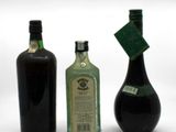 three bottles of liquor sitting next to each other on a white surface