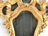 a gold frame with a mirror on it on a wall