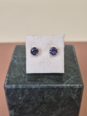 a pair of blue sapphire earrings sitting on top of a marble block