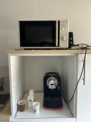 un micro-ondes et une cafetière posés sur une petite étagère