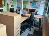 a desk with two computers and a chair in a room