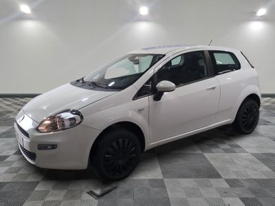 la petite voiture blanche est garée sur un carrelage à carreaux