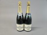 two bottles of champagne sitting next to each other on a table