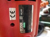 a close up of a red drill with a sticker on it