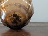 a glass vase sitting on top of a wooden table