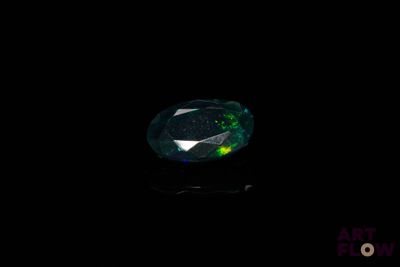 un gros plan d'un diamant vert et noir sur une surface noire