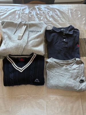trois polos pour homme disposés sur un lit devant une fenêtre