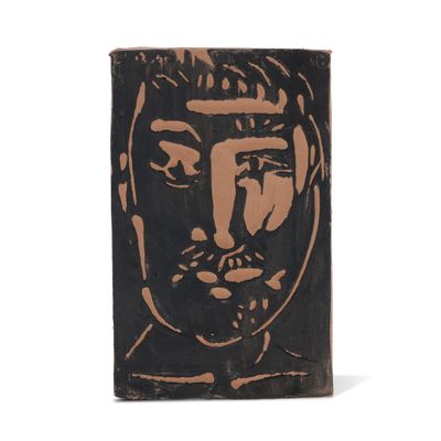 une image représentant un bloc de bois sur lequel est dessiné le visage d'un homme