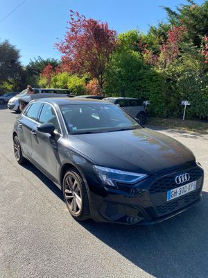 a black audi is parked on the side of the road
