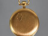 an old gold pocket watch with a chain hanging from it ' s side