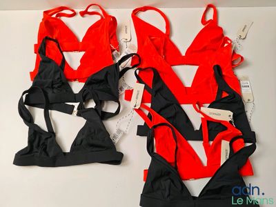 une paire de combinaisons de lingerie rouges et noires posées sur une table blanche