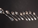 six spoons are lined up in a row on a black surface