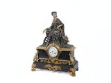une statue d'un homme assis au sommet d'une horloge