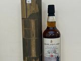une bouteille de whisky posée à côté d'une boîte en bois sur une table