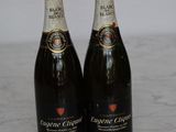 two bottles of champagne sitting on top of a marble counter top