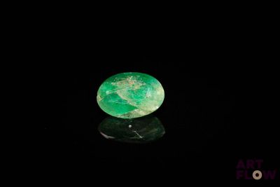 a close up of a green stone on a black surface
