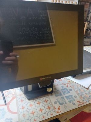 a computer monitor sitting on a desk with a chalkboard on it