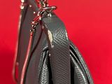 a close up of a black purse on a red background